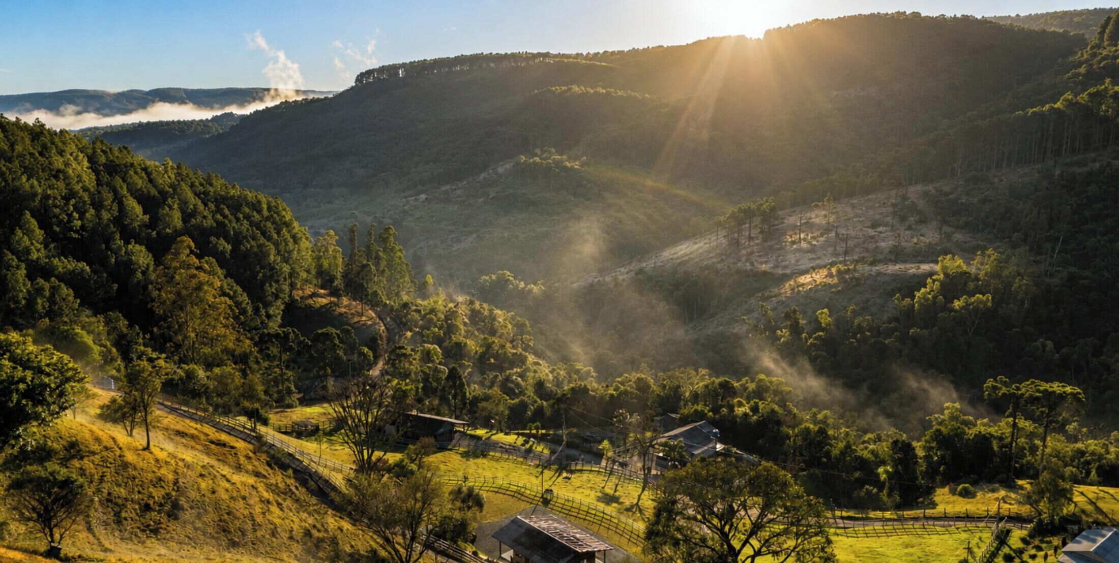 A rural landscape with a valley, a small house, and a fence.