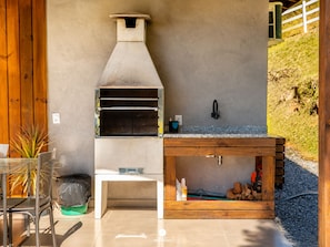 An outdoor kitchen with a built-in oven, a sink, and a wooden counter. - Casa Du - Alfredo Wagner - SC (Alfredo Wagner)