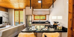 A modern kitchen with a central island, wooden ceiling, and large windows. - Casa Du - Alfredo Wagner - SC (Alfredo Wagner)