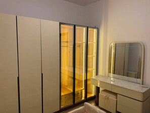 Ein Badezimmer mit Waschtisch, Spiegel und einem Schrank mit Glastüren.