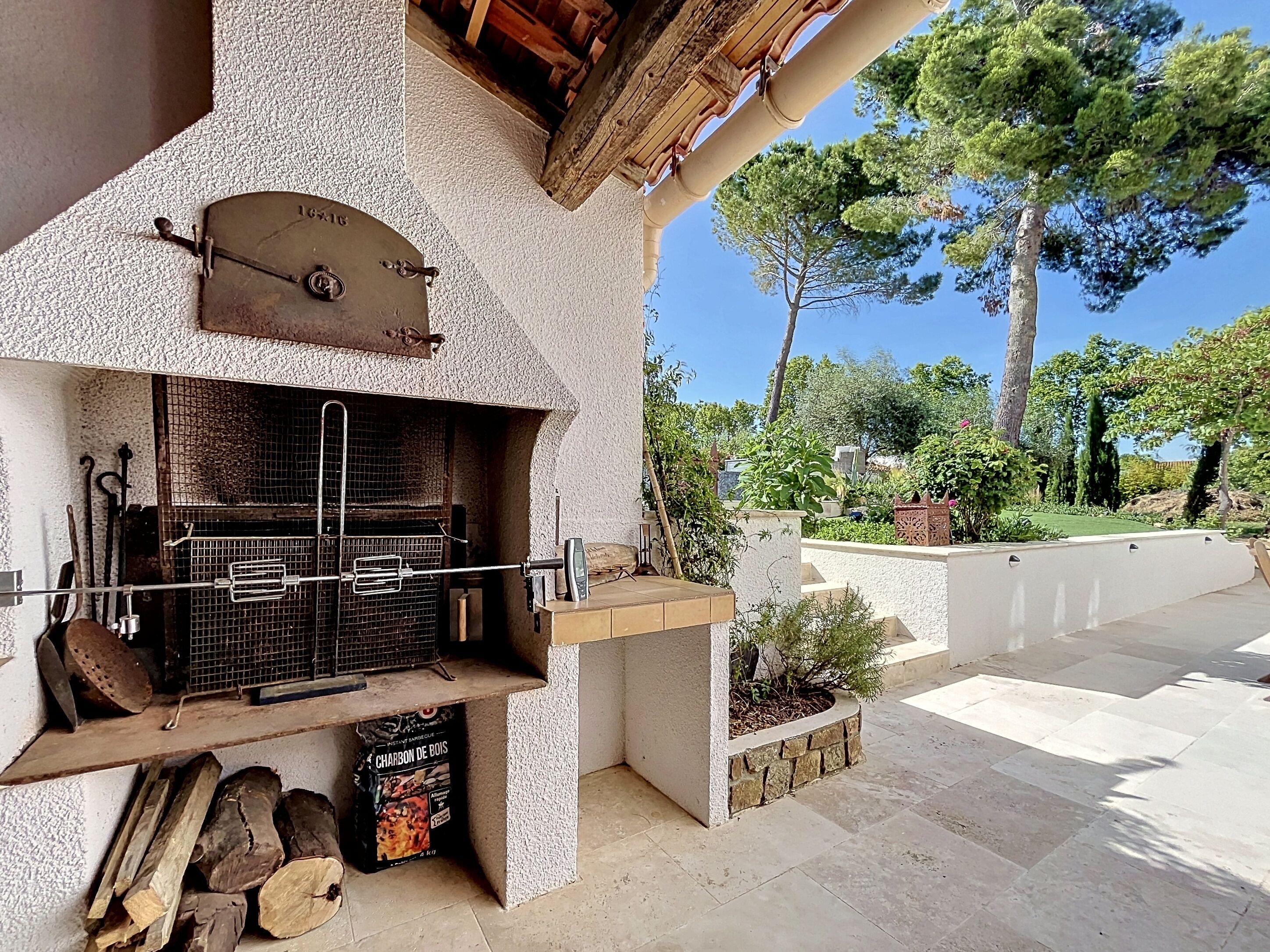 Ein Grillbereich im Freien mit Grill, Kochgeschirr und Holzkohlebeutel.