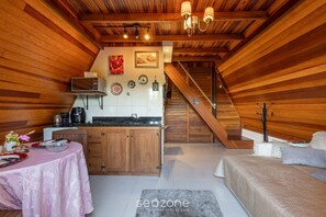 A cozy attic bedroom with a wooden ceiling, a kitchen area with a microwave, and a staircase leading to an upper level. - Magic Cabin in Front of Beto Carrero - Trs0003 (Penha)