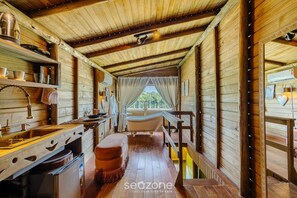 A wooden cabin interior with a bathtub, wooden shelves, and a window with curtains. - Cabin in Front of Beto Carrero W/bathtub Trs0004 (Penha)
