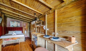 A wooden cabin interior with a bed, a small kitchenette, and a dining area. - Cabin in Front of Beto Carrero W/bathtub Trs0004 (Penha)