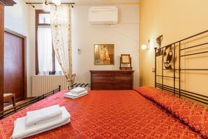 A hotel room with a bed, a dresser, a radiator, and a window with curtains. - Gemma apartment in Venice (Venezia)