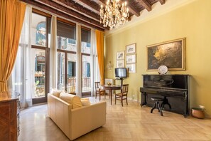 A living room with a sofa, a piano, and a television. - Gemma apartment in Venice (Venezia)
