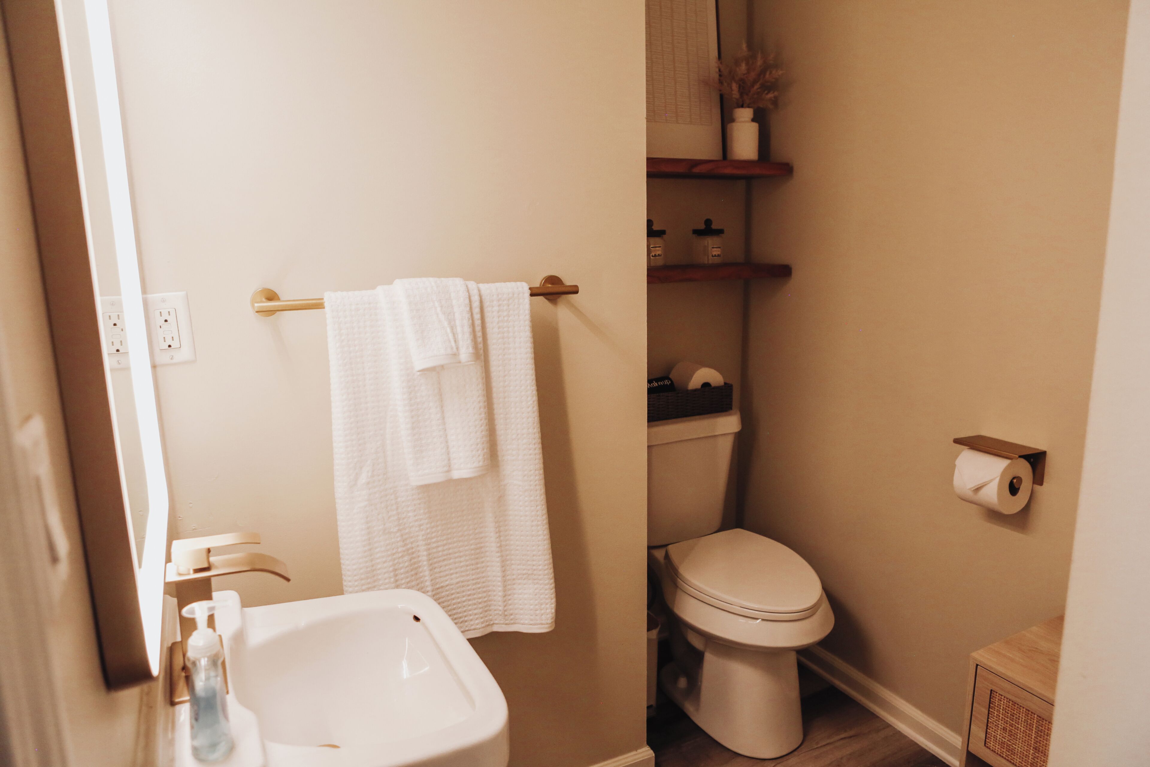 Een badkamer met een wit wastafelmeubel, toilet en handdoekhouder.