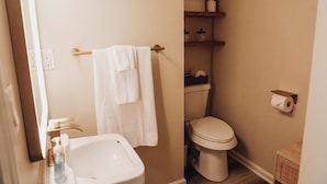 A bathroom with a white sink, a toilet, and a towel rack.