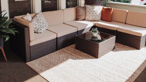 A sectional sofa with multiple cushions, a coffee table, and a large potted plant.
