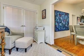 A room with a closed door, a white cabinet, a large abstract painting, and a chair. - 2 Mi to Coligny Beach! HHI Home w/ Deck (Hilton Head Island)