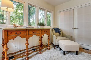 A room with a wooden dresser, a chair, and a large window with a view of trees. - 2 Mi to Coligny Beach! HHI Home w/ Deck (Hilton Head Island)