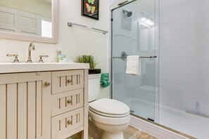 Een badkamer met toilet, wastafel en douche.