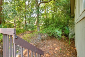 A wooden deck with a metal gate, surrounded by dense foliage and trees. - 2 Mi to Coligny Beach! HHI Home w/ Deck (Hilton Head Island)