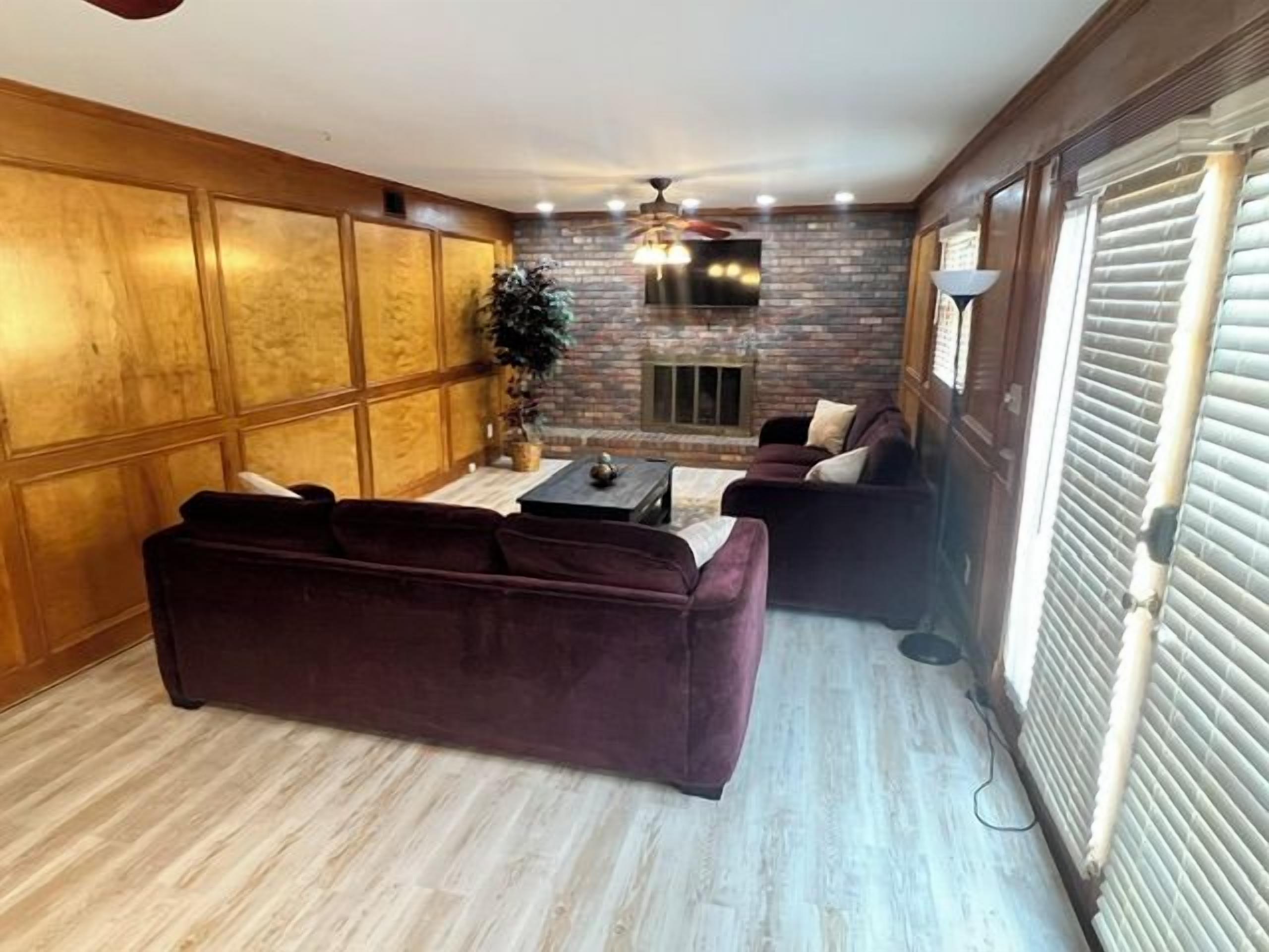 A living room with a sofa, a coffee table, and a fireplace.