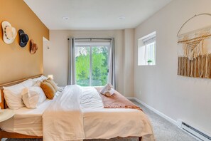 A bedroom with a large bed, a window with a view of trees, and a wall-mounted artwork. - Blue Sky Retreat w/ 3rd-Floor Mtn Views, Starlink (Bailey)