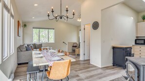 Eine moderne Küche mit Essbereich, integriertem Herd und großem Fenster für natürliches Licht.
