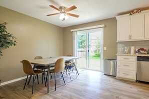 Una cucina moderna con zona pranzo, pavimento in legno e ventilatore a soffitto.