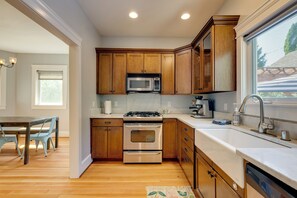 A modern kitchen with wooden cabinets, stainless steel appliances, and a large window. - Walk to Capitol Campus! 'Stellar & Bloom Olympia' (Olympia)