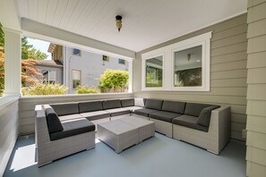A covered outdoor seating area with a sectional sofa and a small table. - Walk to Capitol Campus! 'Stellar & Bloom Olympia' (Olympia)