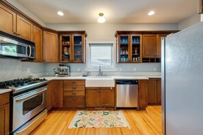 A kitchen with wooden cabinets, a stainless steel stove, a microwave, and a dishwasher. - Walk to Capitol Campus! 'Stellar & Bloom Olympia' (Olympia)
