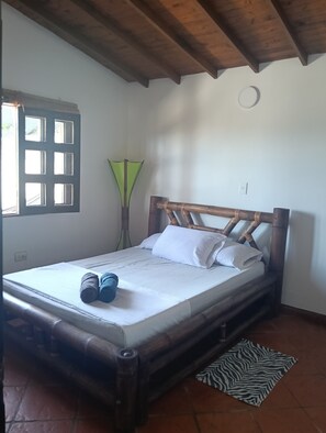 A room with a bed, a window, a lamp, and a patterned rug. - Welcoming 3-bedroom house in Guatape perfect for your getaway (Guatape)