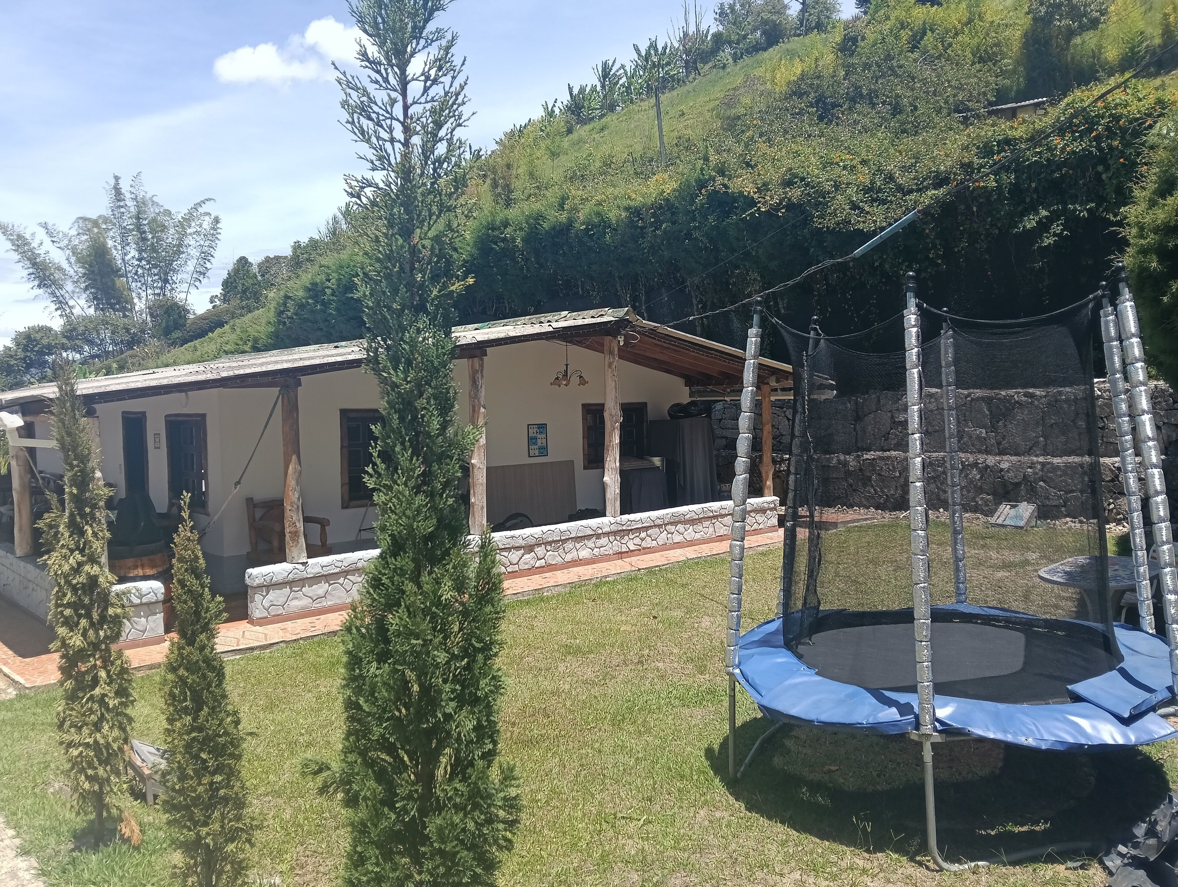 Ein Haus mit Veranda, Trampolin und kleinem Garten.