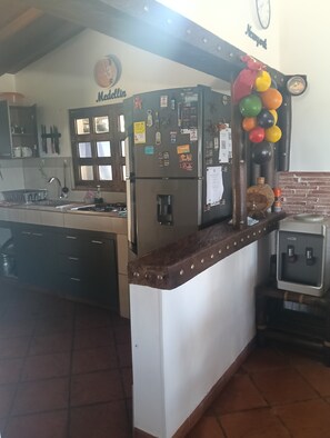 A kitchen with a refrigerator, a clock, and a wall-mounted clock. - Welcoming 3-bedroom house in Guatape perfect for your getaway (Guatape)