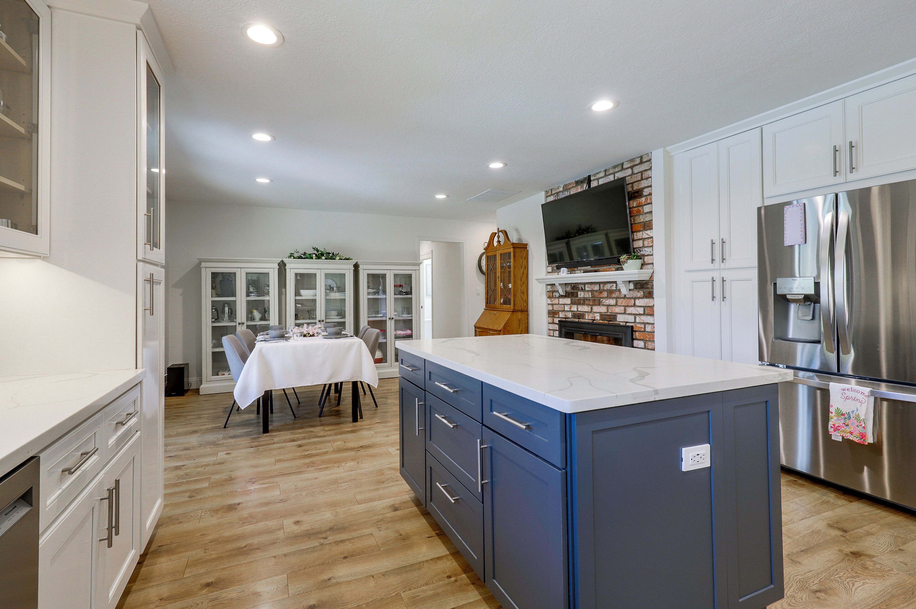 Una cocina moderna con una isla central, electrodomésticos integrados y un comedor con una mesa dispuesta para cuatro.