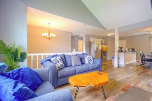 A living room with a sofa, a coffee table, and a chandelier. - 11 Mi to Overland Park: Olathe Mid-Term Stay (Olathe)