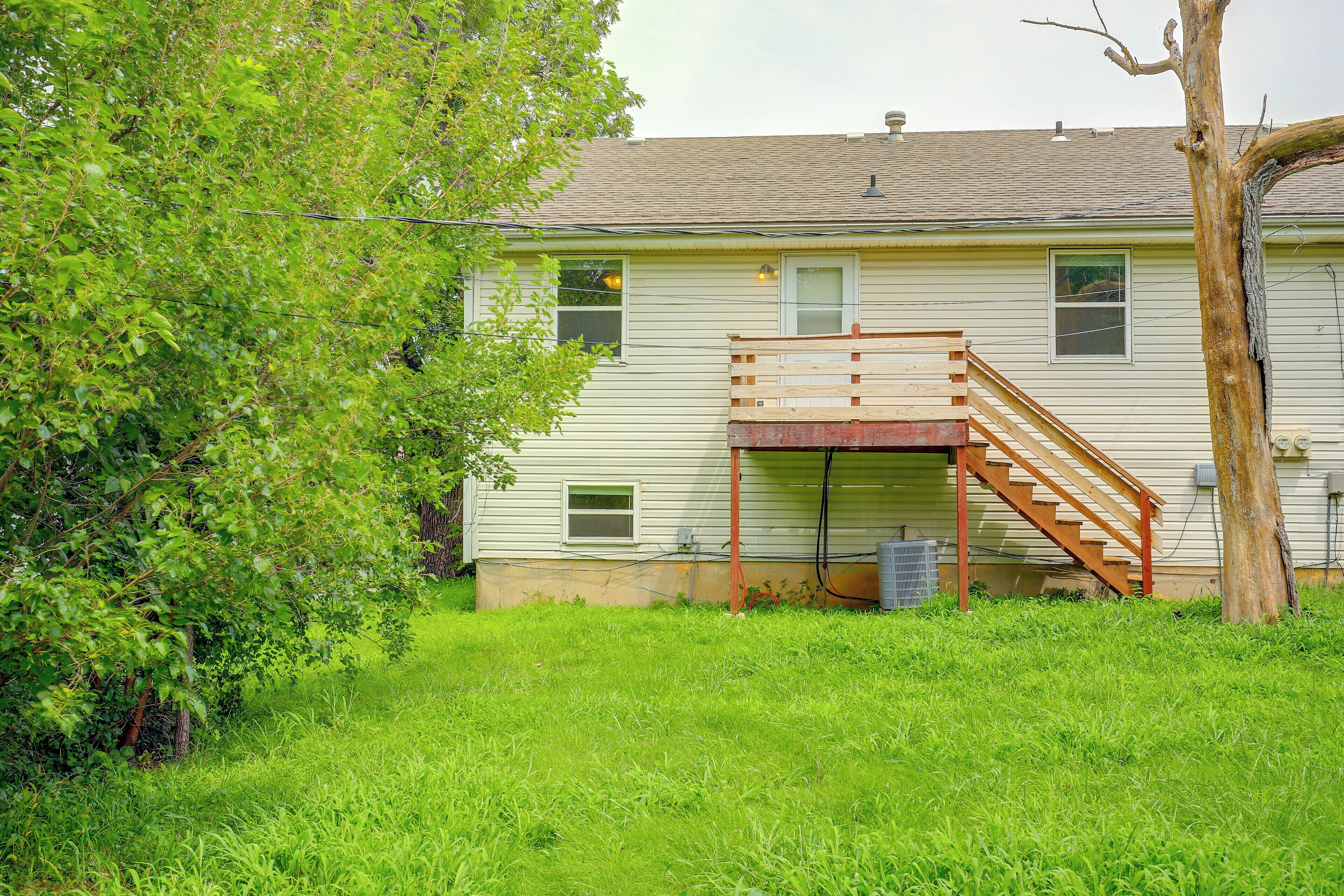 A single-story house with a wooden staircase leading to a covered porch.