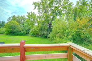 A wooden deck with a view of a grassy field and trees. - 11 Mi to Overland Park: Olathe Mid-Term Stay (Olathe)