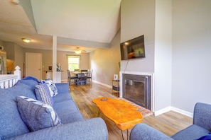 A living room with a fireplace, a television mounted above it, and a dining area in the background. - 11 Mi to Overland Park: Olathe Mid-Term Stay (Olathe)
