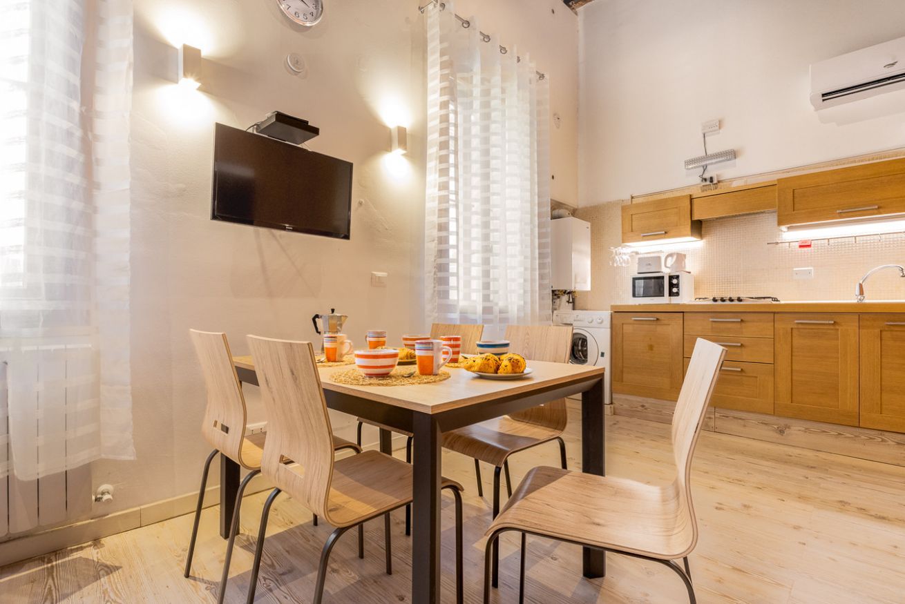 A modern kitchen with wooden cabinets, a microwave, and a coffee machine.