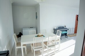 A room with a white table and chairs, a piano, and a globe on a stand. - Lovely  apartment with AC in vibrant Your Paradise Coastal Retreat in Nagua (Nagua)