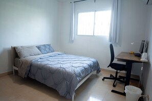 Ein Schlafzimmer mit einem Bett, einem Schreibtisch und einem Stuhl.