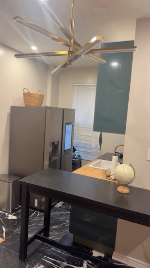 A modern bathroom with a marble floor, a sink with a globe, a mirror, and a ceiling light fixture. - Cozy 1-bedroom apartment in lovely Brooklyn with AC (brooklyn)