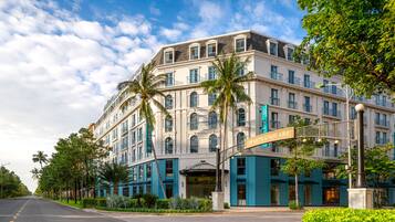 A multi-story hotel with a classic architectural style, featuring a prominent entrance and a balcony.