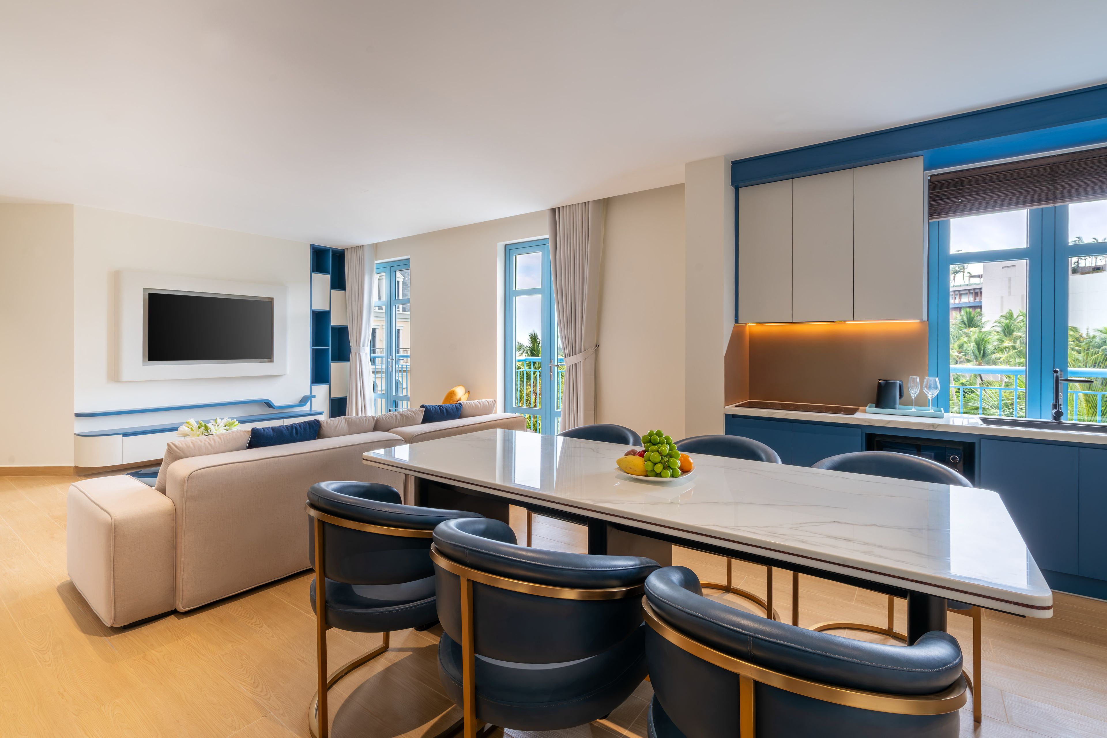 Una sala moderna con sofá, una mesa de comedor y una cocina con vistas.