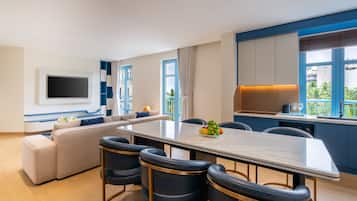 Una sala moderna con sofá, una mesa de comedor y una cocina con vistas.