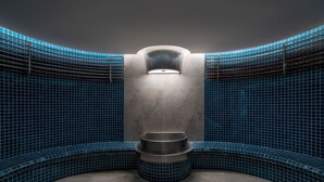 A modern bathroom with a curved design, featuring a central sink and a wall-mounted light fixture. - AMÉRYS Hotel Phu Quoc (Phu Quoc)