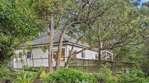 A house surrounded by lush greenery and trees. - Cottage plus grand/parents retreat (MACMASTERS BEACH)