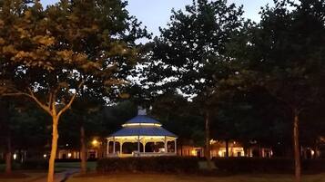A gazebo with a dome roof surrounded by trees and pathways.