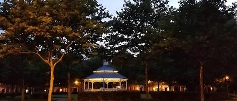 A gazebo with a dome roof surrounded by trees and pathways.
