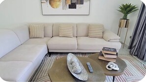 Ein Wohnzimmer mit einer Couch, einem Couchtisch und einer Pflanze.