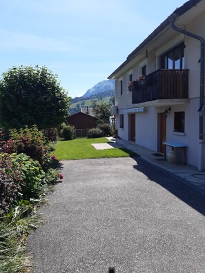 A residential street with a paved driveway leading to a house with a balcony. - Welcome to Marco's! A comfortable apartment in the countryside, for 4 people. (Marthod)