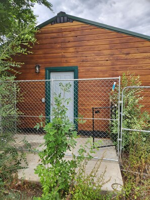 A wooden building with a green door and a chain-link fence in front. - Hunter's Paradise in Northeast Montana (Culbertson)
