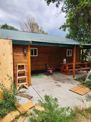 A wooden cabin with a covered patio, a ladder, and a picnic table. - Hunter's Paradise in Northeast Montana (Culbertson)