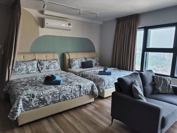 A hotel room with two beds, a sofa, a window with curtains, an air conditioning unit, and a ceiling-mounted security camera. - CozyStay 3BR at Arte Cheras 4-Min Walk to MRT & Close to TRX/KLCC/Bukit Bintang (Kuala Lumpur)