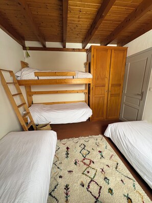 A dormitory room with two bunk beds, a wooden ladder, a wardrobe, and a patterned rug. - Beautiful, comfortable 2-bedroom apartment for 6 people, just 50 meters from the Linga chairlift! (Châtel)
