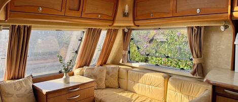 A cozy interior with a sofa, a small table, and a window with curtains.